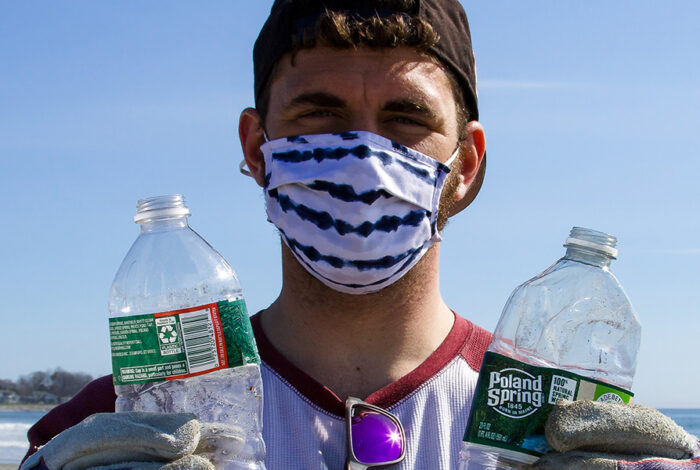 man on beach holding trash