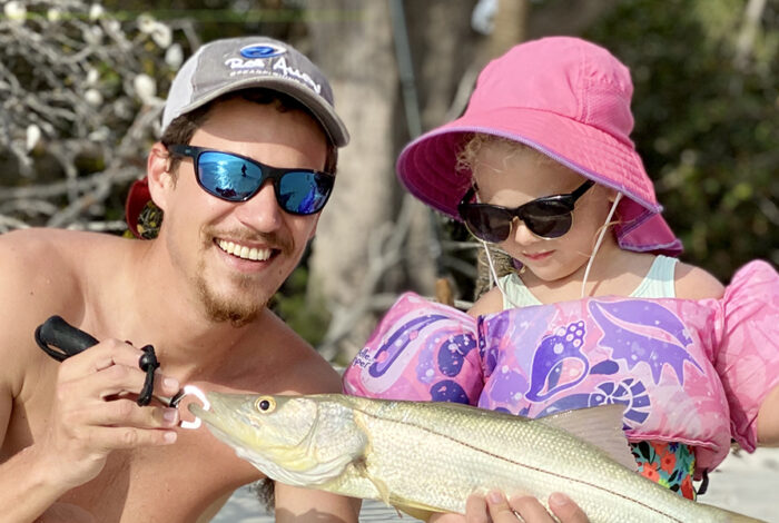 dad and daughter posing with caught fish