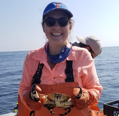 kate rose on a boat, holding a crab
