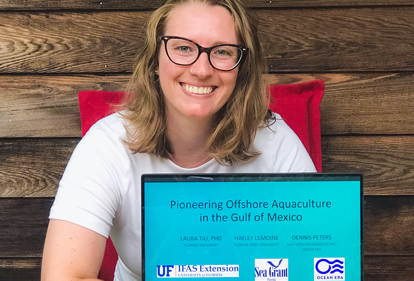 harvest intern showcases powerpoint presentation on offshore aquaculture on labtop