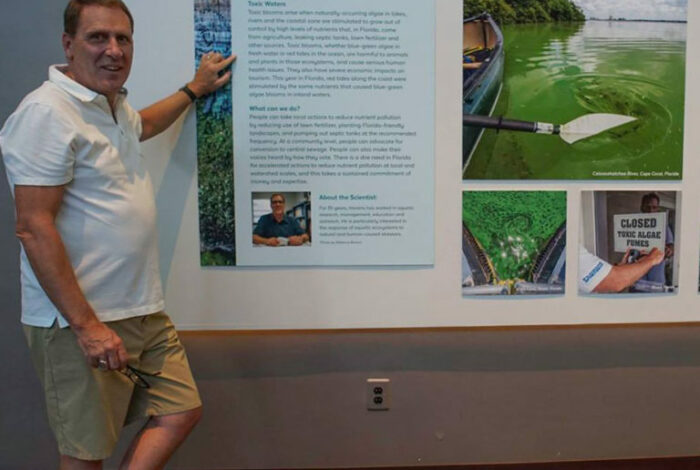 Karl havens pointing to poster presentation of Toxic Algae: Florida's Summer of Slime