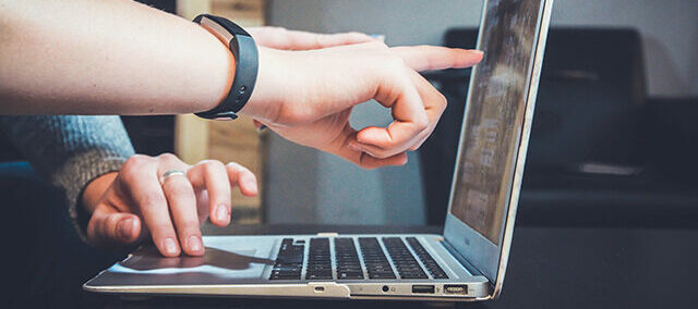 hands pointing at computer screen