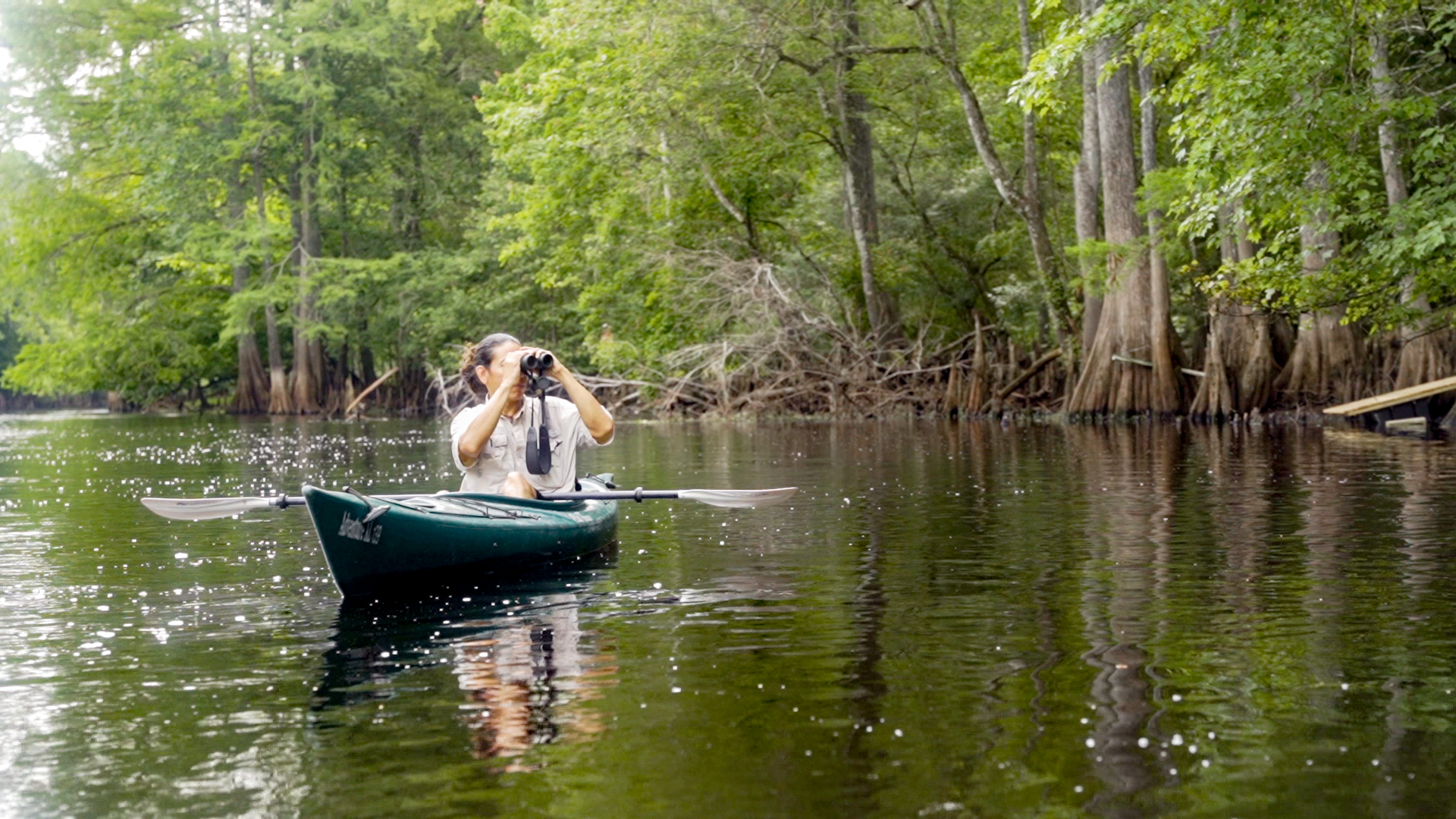 Armando Ubeda in kayak holding binoculars