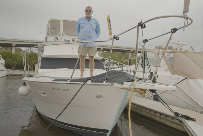 Dave Fuller standing aboard boat at marina