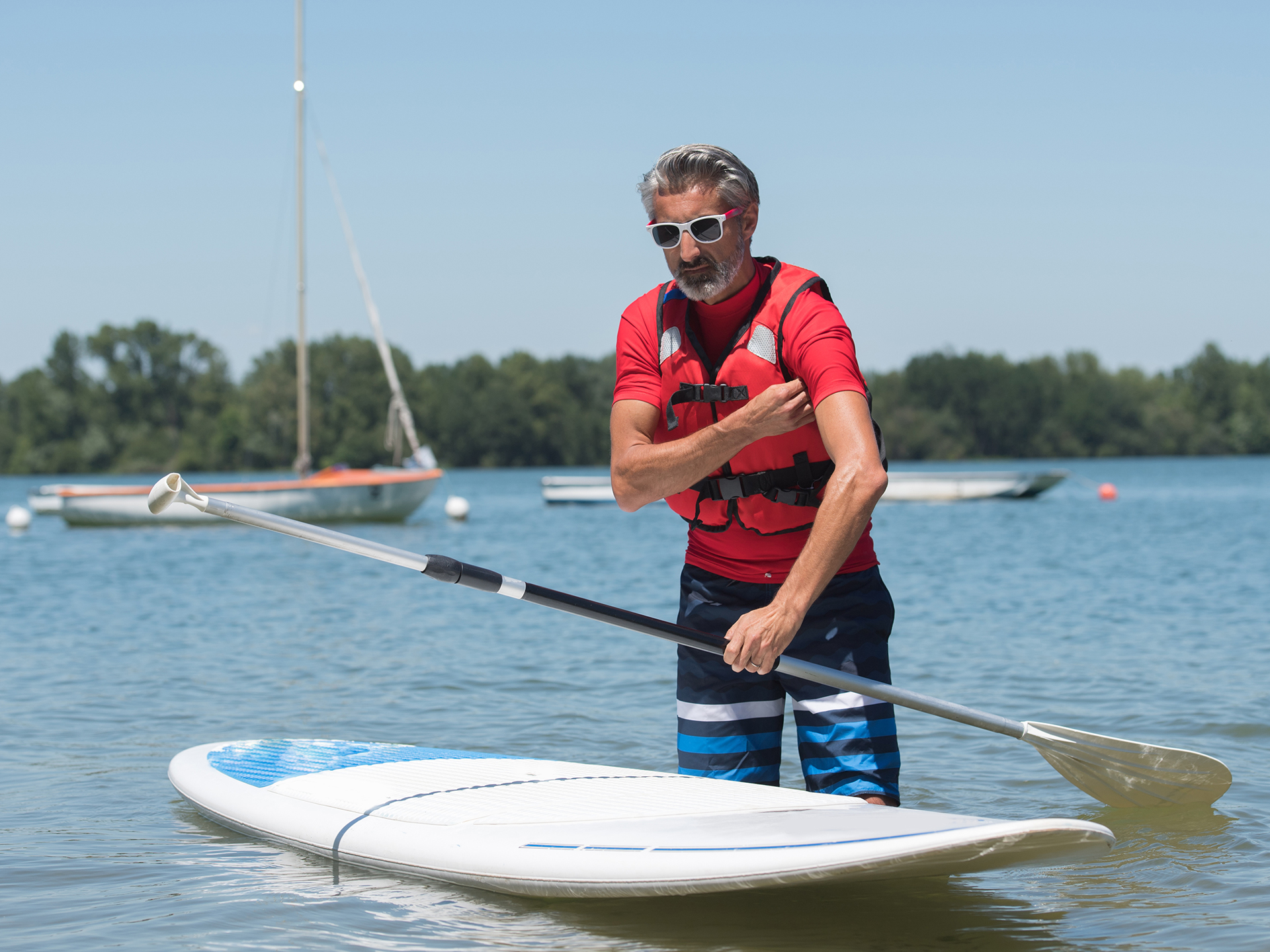 man next to a stand-up paddle board on water