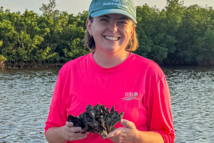 Olivia blondheim holding a cluster of oyster shells