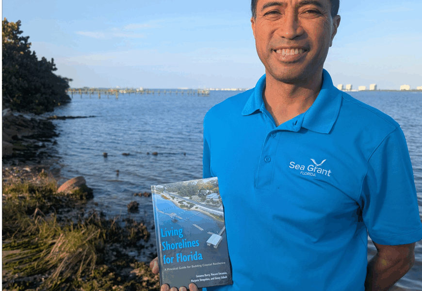 Vincent Encomio holding the book living shorelines for Florida