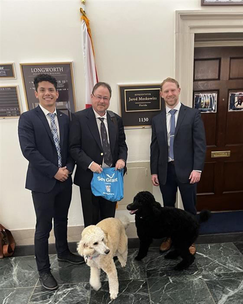 Roberto (left) and Dr. Charles Sidman (center) meet with Representative Moskowitz’s staff (right), alongside his dogs, Salt and Pepper.