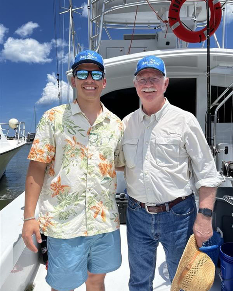 Roberto (left) stands beside Representative Rutherford (right) on a boat during a fishing trip off the coast of St. Augustine.