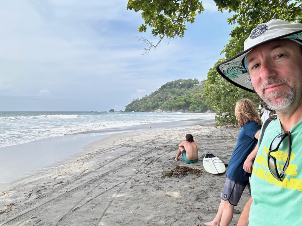 peter thosteson on a beach with friends and family in the background