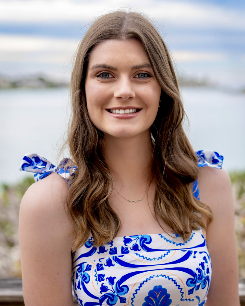 Meredith Pratt smiling in front of a shoreline.