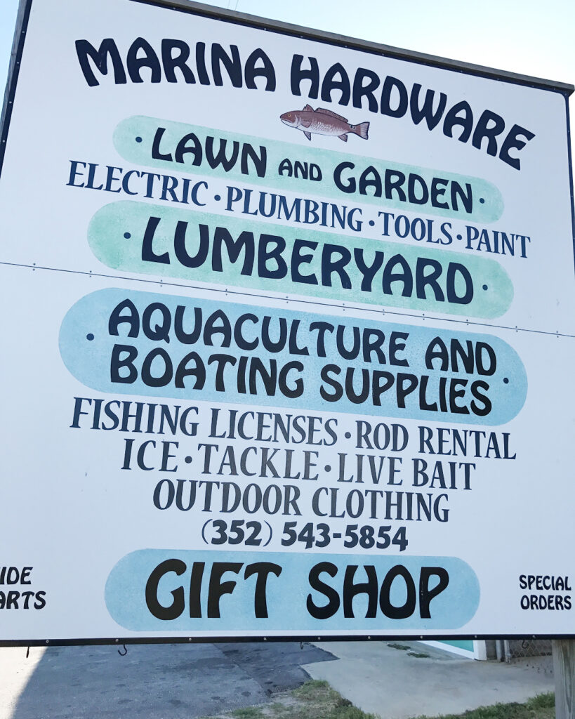 a sign that says marina hardware with mentions of items the store carries