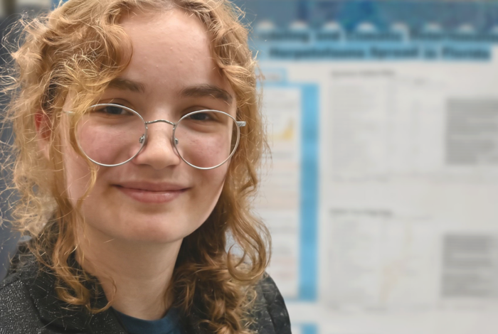 Elena Beck in front of science fair poster.