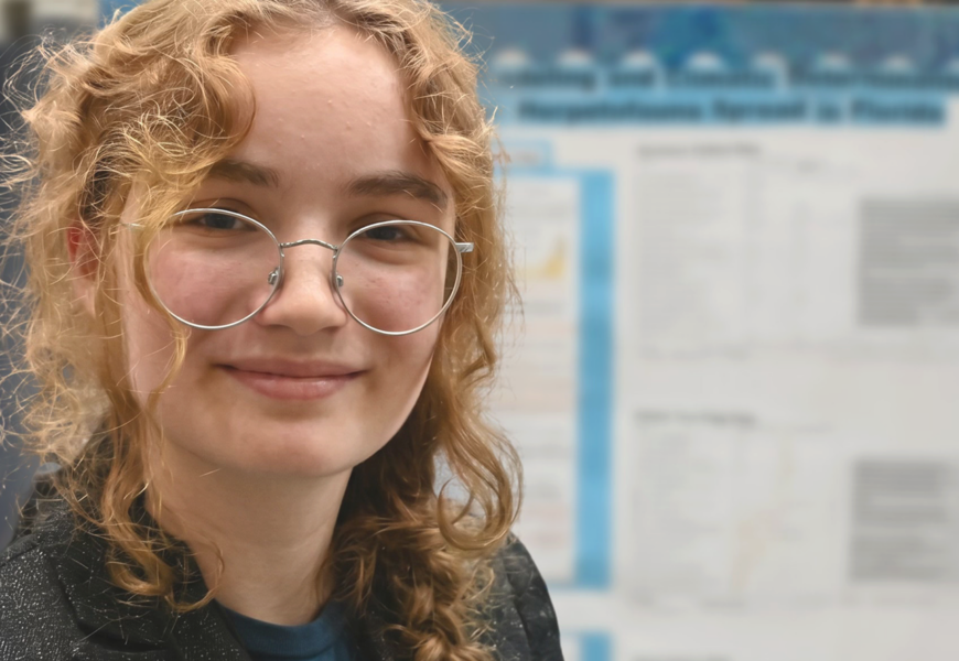 Elena Beck in front of science fair poster.
