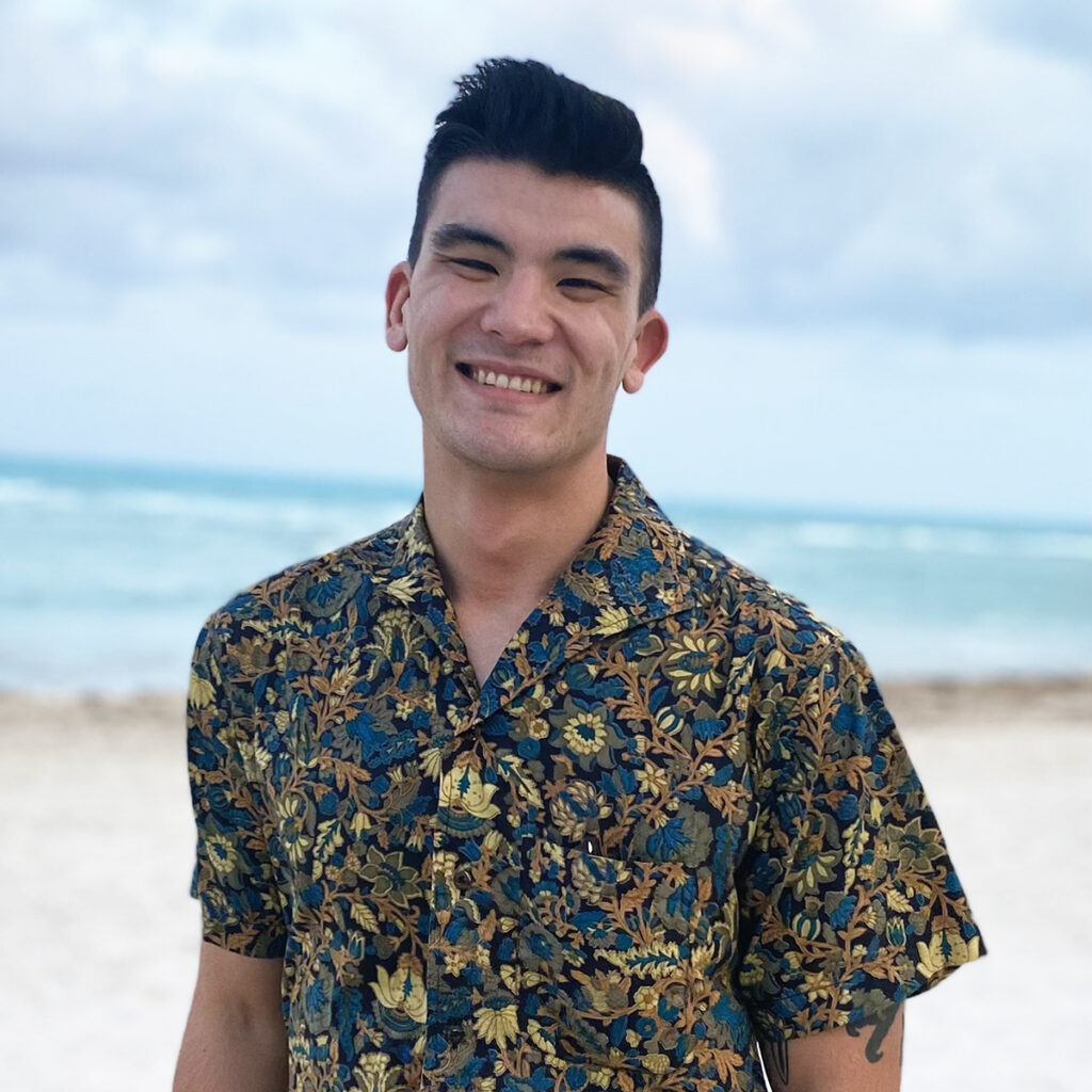 Rainer Moy-Huwyler smiling in front of ocean coastline